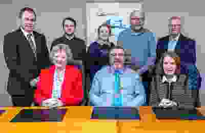 Image of the People First Credit Union board of directors with three people sitting down and five people standing behind them.