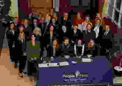 A large group of people standing together looking at the camera