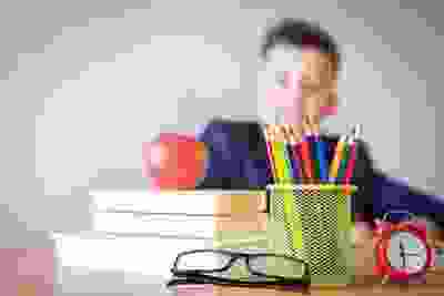 Student with colouring pencils and school books